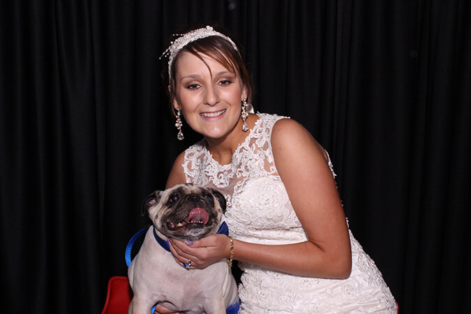 wedding bride with her dog taking pictures at the manor at coffee creek photo booth