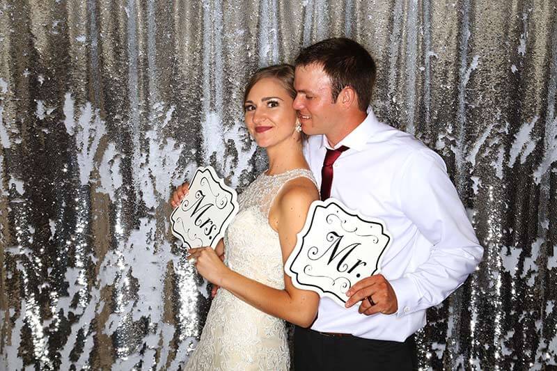 wedding couple and bridesmaids pose in front of photobooth camera.  Snap Me Crazy offers all types of backdrops, and photo strip designs.