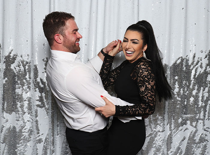 couple in booth photo booth attendant laughing with guests as they have their pictures snapped in our snap me crazy photobooth in edmond, oklahoma.