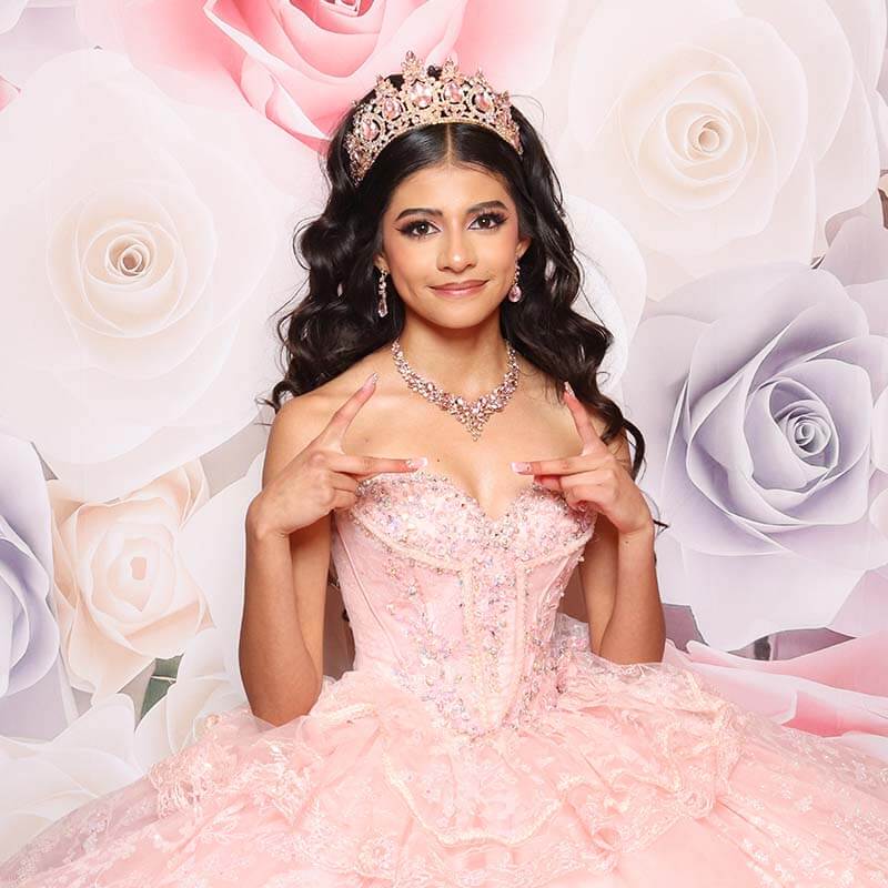 Quinceañera_event A beautiful teenage girl wearing a pink gown poses inside a Snap Me Crazy Photo Booth at her Quinceañera