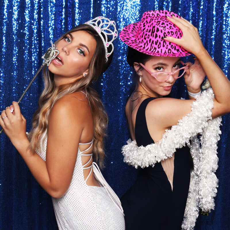 girls_posing_blue A wedding couple pose in front oif a photo booth as the girl teases her husband and the camera.