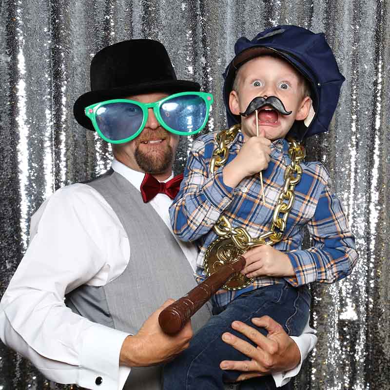 kids A dad and kid wearing props acting funny towards the camera.