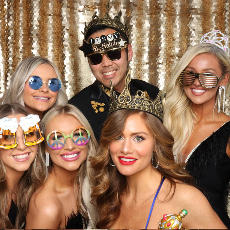 models A man surrounded by lovely ladies in front of a gold backdrop at an event in OKC, OK
