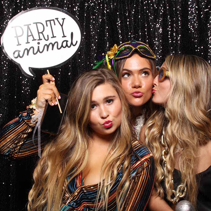 party_girls_funny_pose A wedding couple pose in front oif a photo booth as the girl teases her husband and the camera.