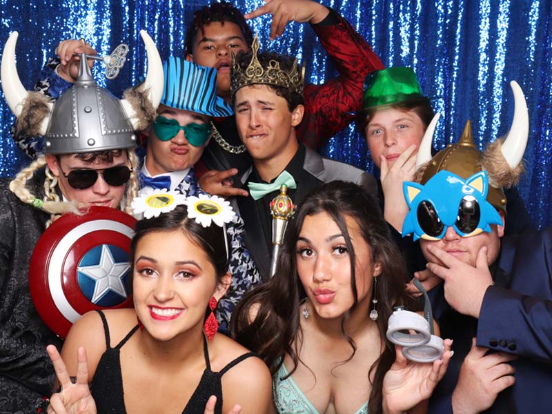promnight photo booth attendant laughing with guests as they have their pictures snapped in our snap me crazy photobooth in edmond, oklahoma.