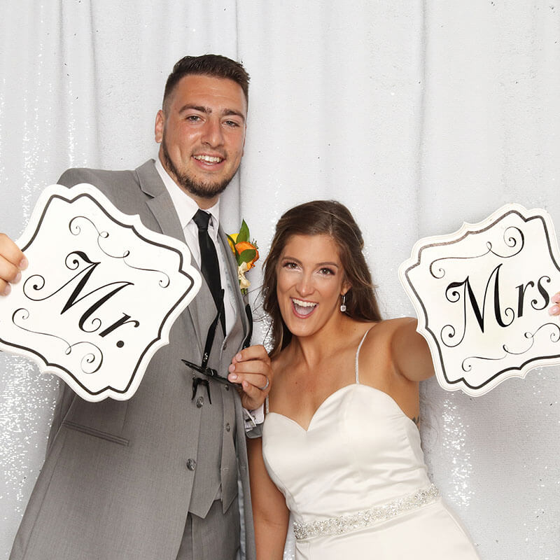 Newlywed couple Posing with Signs A newlywed couple hold signs that read "Mr. and Mrs. A beautiful shot with good facial expression and beauty lighting.