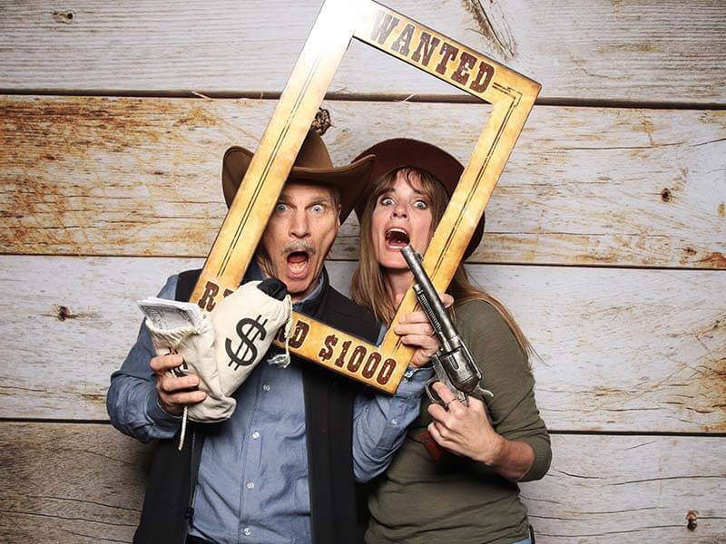 photo booth attendant laughing with guests as they have their pictures snapped in our snap me crazy photobooth in edmond, oklahoma.